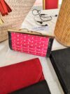 Rigid pouch in bright pink leather and raffia.