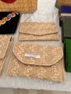 Beige gold embroidered pouch with curved flap.