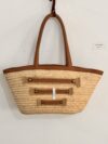 Natural basket with three decorative leather straps.