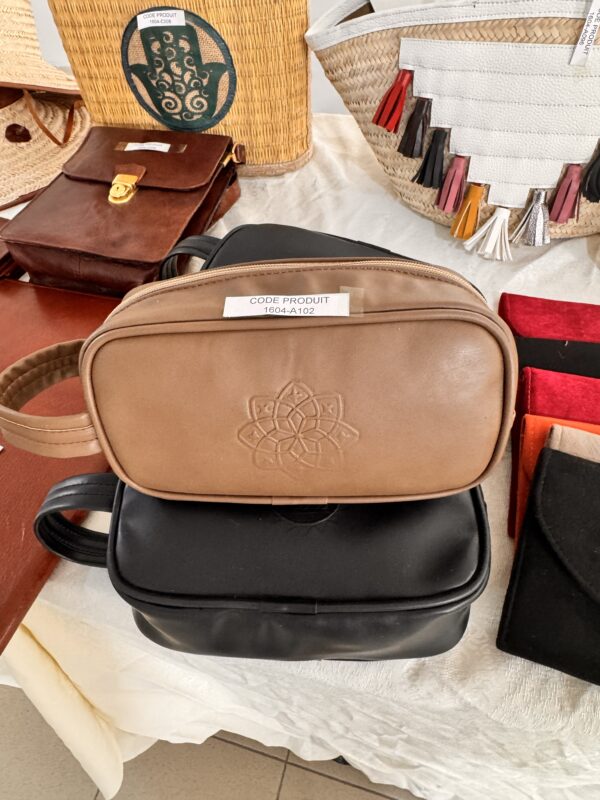Beige leather bag with embossed geometric pattern.