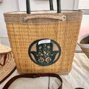 Straw bag with khomsa pattern cut into the burlap.